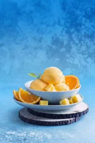 orange pineapple ice cream bowl on a blue textured background