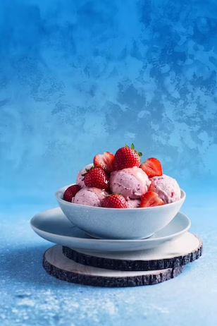 Strawberry ice cream bowl on a blue textured background